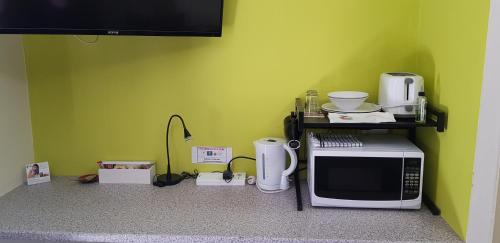 a microwave sitting on top of a kitchen counter at Gold Coast Airport Motel - Only 300 Meters To Airport Terminal in Gold Coast