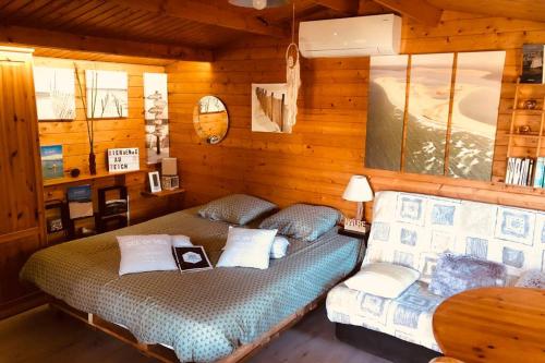une chambre avec deux lits dans une cabane en rondins dans l'établissement La cabane de Carol au coeur du bassin d'Arcachon, au Teich