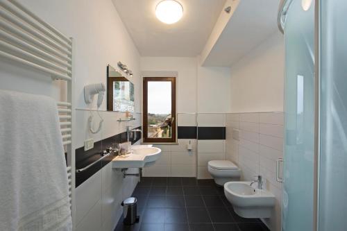 a bathroom with two sinks and two toilets at Hotel Alma Domus in Siena