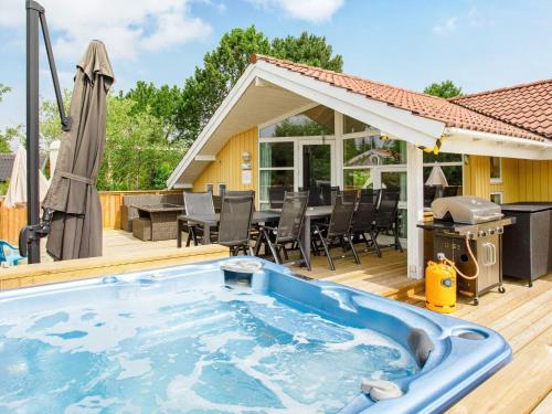 a hot tub on a deck with a grill at 10 person holiday home in V ggerl se in Marielyst