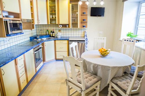 a kitchen with a table with a bowl of fruit on it at 4 bedroom 166m2 apartment with sauna in the city 600m from the beach in a quiet family residence in Kuressaare
