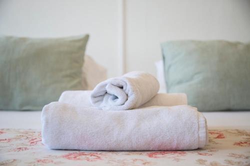 a stack of towels sitting on top of a bed at Escalera al Puerto Guest House in Valparaíso