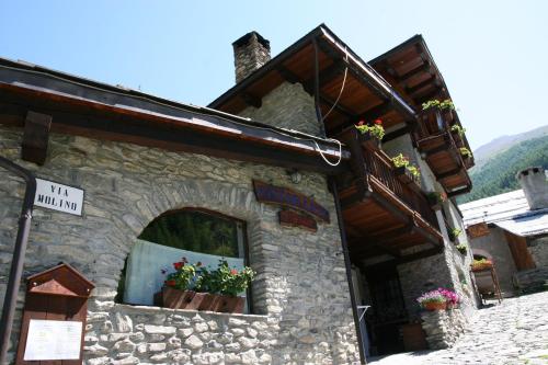 a stone building with flowers in a window at Chalet Della Guida in Bardonecchia