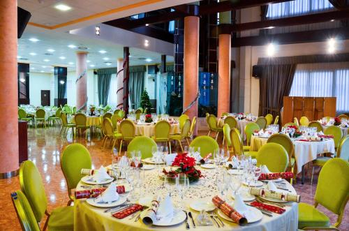 a banquet hall with white tables and yellow chairs at La Familia Gallo Rojo in El Campello