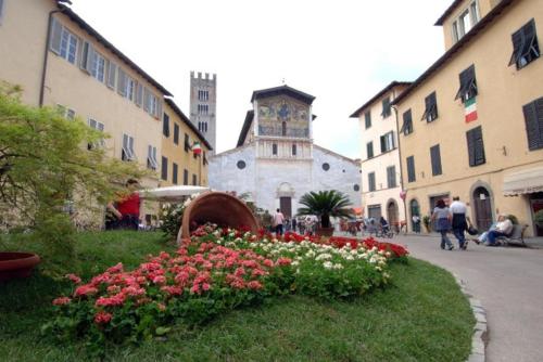 a group of buildings with a clock tower and flowers at BeB Angelini dal 1911 in Lucca