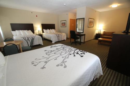 Habitación de hotel con 2 camas y sofá en Bowman Inn and Suites, en Bowman