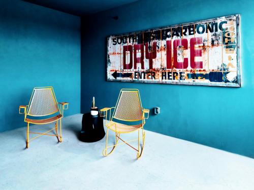 two chairs in a room with a painting on the wall at Hotel Dryce in Fort Worth