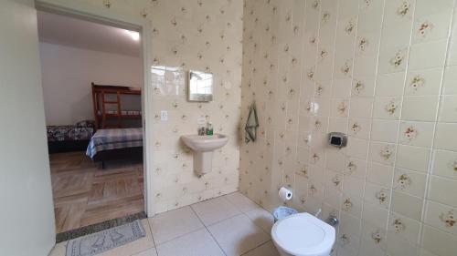 a bathroom with a toilet and a sink at Suítes econômica Flor de Maria in Caraguatatuba