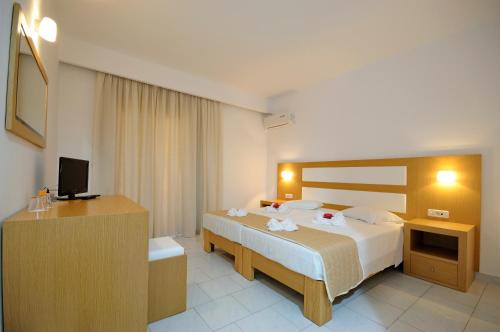 a hotel room with a bed and a desk at Summer Village of Hippokrates - Adults only in Marmari