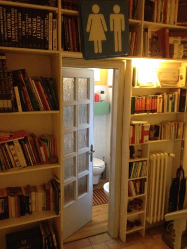 a bathroom with a toilet and a book shelf with books at Casa Olivia in Florence