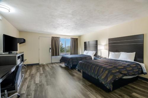 a hotel room with two beds and a flat screen tv at Alpine Motel in Abingdon