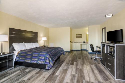 a hotel room with a bed and a flat screen tv at Alpine Motel in Abingdon