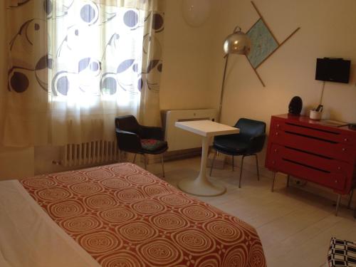 a bedroom with a bed and a desk and chairs at Casa Olivia in Florence