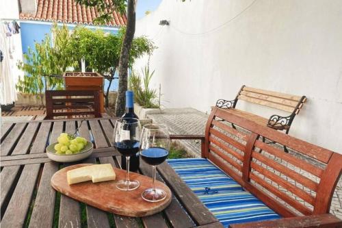 a wooden table with two glasses of wine and cheese at Almirante24 - Apartment with Garden - Ajuda Palace & Royal Treasure Museum in Lisbon