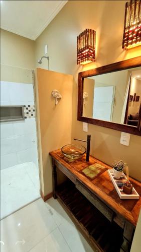 a bathroom with a sink and a mirror at Pousada Paraíso Gaia in Praia do Rosa