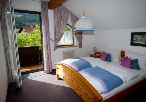 a bedroom with a bed and a large window at Apartmenthaus Berdnik in Kötschach