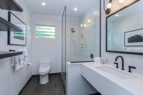 Baño blanco con lavabo y aseo en Hanalei Beachfront Cottage home, en Hanalei
