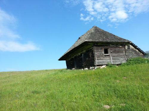 an old house sitting on top of a grassy hill at Pensiunea Crai Nou in Şirnea