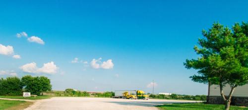 a road with two yellow trucks parked on it at Super 8 by Wyndham McLean/Bloomington SW in McLean