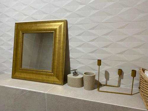 a bathroom with a gold mirror and two towels at SAND Apartment in Žilina