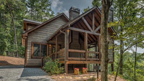 una cabaña en el bosque con un porche envolvente en Unplug, en Ellijay
