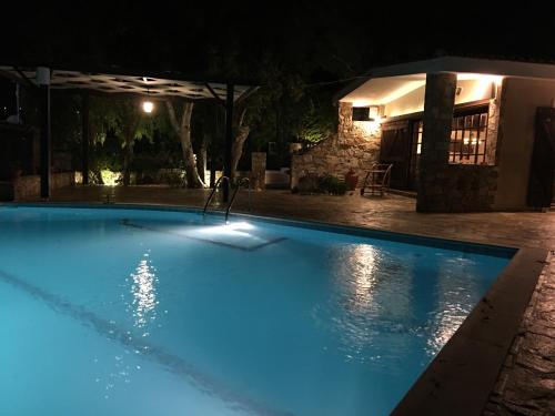 a swimming pool lit up at night at Luxury villa with stunning panoramic sea view in Keratea