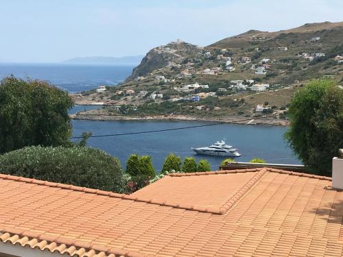 a boat in a body of water with a cruise ship at Luxury villa with stunning panoramic sea view in Keratea