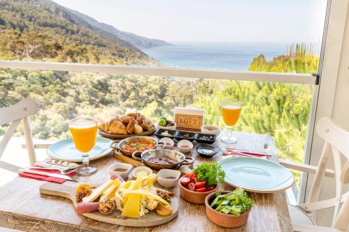 a table with food and drinks and a view of the ocean at Ölüdeniz Loft - Adults Only in Oludeniz
