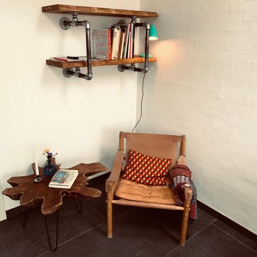 a chair with a pillow sitting next to a table at Rikke og Franks Svineri in Lemvig