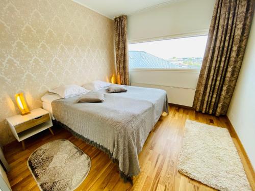 a bedroom with a bed and a large window at Cozy Lootsi Residence with Sauna and Balcony - Tallinn city centre in Tallinn