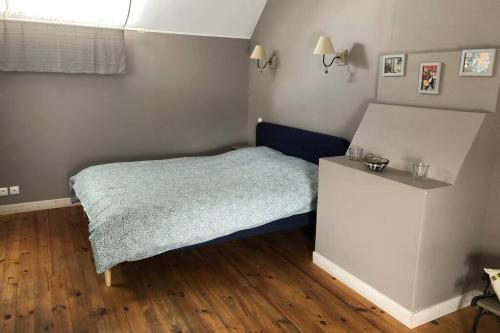 a small bedroom with a bed and a table at Maison au pied des dunes, 200m de la plage in Montmartin-sur-Mer