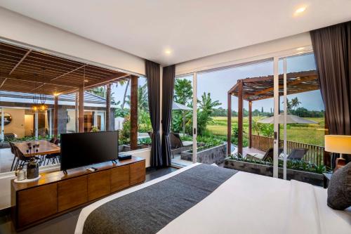 Coconut Grove Villa by BaliSuperHost في أوبود: غرفة نوم بسرير كبير ونافذة كبيرة
