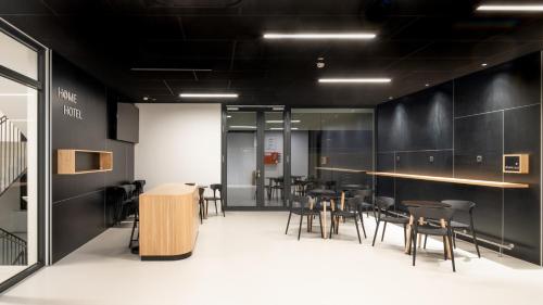 a restaurant with black walls and tables and chairs at Hotel AT HOME - late arrival self check in in Graz