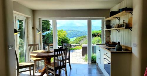 a kitchen with a table and a view of a mountain at Ty Farm Retreat - Farmhouse Studio - Mountain View in Eglwys-Fâch