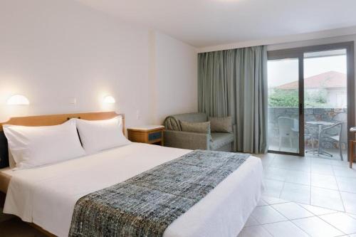 a hotel room with a bed and a balcony at Akti Taygetos - Conference Resort in Kalamata