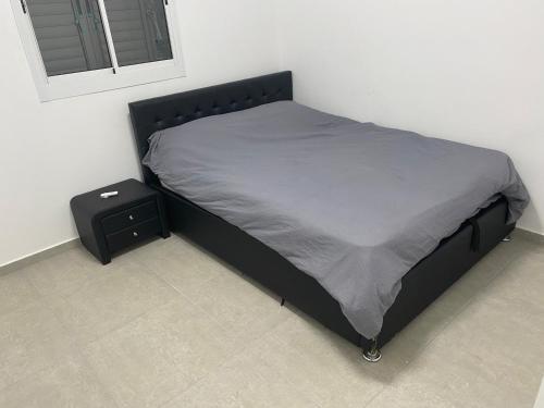 ein Bett mit einem schwarzen Bettrahmen und einem Nachttisch in der Unterkunft New! Luxus Holon for 11 people (5min from TLV) in Cholon