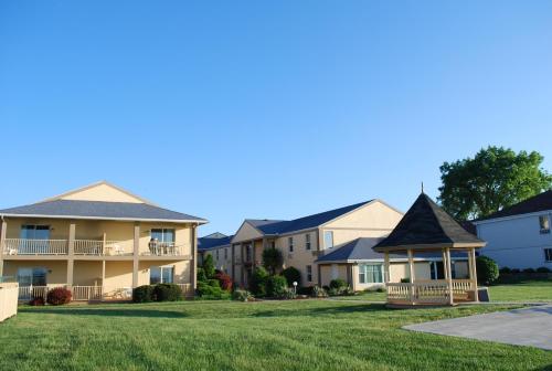 a large house with a large lawn and trees at Clinton Inn & Suites in Port Clinton
