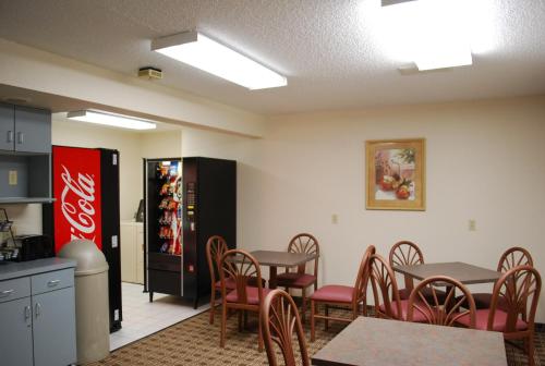 a restaurant with tables and chairs and a cocacola refrigerator at Clinton Inn & Suites in Port Clinton