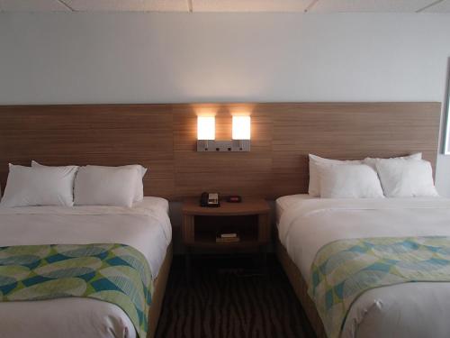 a hotel room with two beds and a night stand at DoubleTree by Hilton Corpus Christi Beachfront in Corpus Christi