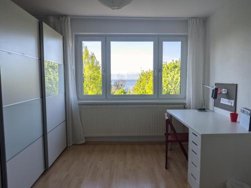 an office with a desk and a large window at Ferienwohnungen Vera & Lea in Friedrichshafen