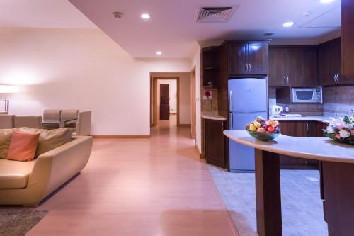 a kitchen and living room with a couch and a table at Al Safir Tower - Residence in Juffair