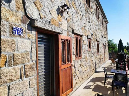 a stone building with a door and a table and chairs at East Mountain Light Brigade in Nangan
