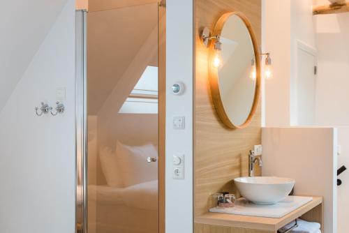 a bathroom with a sink and a mirror at Fietshotel Zee van Tijd Holwerd in Holwerd
