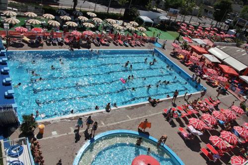 uma grande piscina com pessoas em Hotel Vera em Riccione
