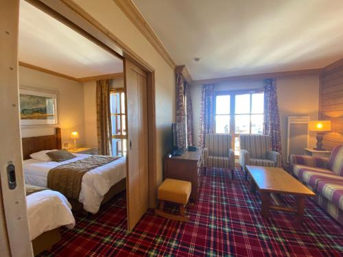 ein Hotelzimmer mit zwei Betten und einer Couch in der Unterkunft Arc 1950 - Résidence Hameau du Glacier in Bourg-Saint-Maurice