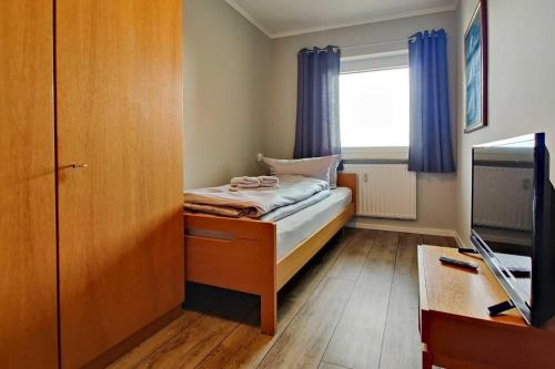 een kleine slaapkamer met een bed en een raam bij Strandhochhaus-Doese-Ferienwohnung-42-SH42 in Cuxhaven