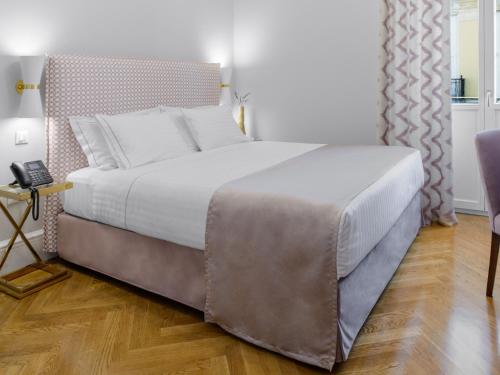 a large bed in a bedroom with a wooden floor at MiraMe Athens Boutique Hotel in Athens