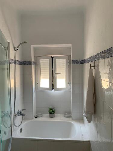 a white bathroom with a tub and a window at Casa Rural San Francisco II in Siles