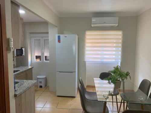 a kitchen with a white refrigerator and a table with chairs at Casa Rural San Francisco II in Siles