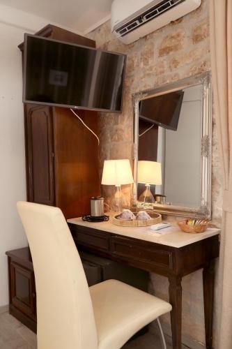 a desk with a mirror and a white chair at Villa Carrara in Trogir